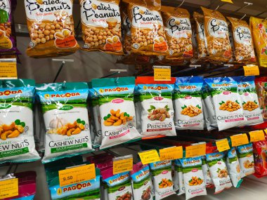 SELANGOR, MALAYSIA - 5 Şubat 2022 Fıstık bazlı atıştırmalıklar ticari paketlerde paketlendi ve satışa sunuldu. Markaya göre sıralanmış ve fiyat etiketi var.. 