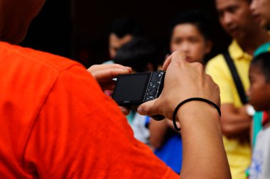 MELAKA, MALAYSIA - 5 Mart 2020: Fotoğrafçı bir olayın fotoğraflarını çekmek için bir kamera kullanıyor. Bir dijital kamera kullanılıyor ve istenen açıya göre ayarlanıyor..