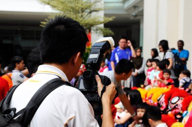 MELAKA, MALAYSIA - 5 Mart 2020: Fotoğrafçı bir olayın fotoğraflarını çekmek için bir kamera kullanıyor. Bir dijital kamera kullanılıyor ve istenen açıya göre ayarlanıyor..