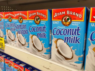 MELAKA, MALAYSIA -NOVEMBER 12, 2022: Ticari paketleme ve süpermarketlerde sergilenen işlenmiş hindistan cevizi sütü üzerine odaklanıldı. Markaya göre sıralanmış ve fiyat etiketi var..