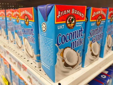 MELAKA, MALAYSIA -NOVEMBER 12, 2022: Ticari paketleme ve süpermarketlerde sergilenen işlenmiş hindistan cevizi sütü üzerine odaklanıldı. Markaya göre sıralanmış ve fiyat etiketi var..