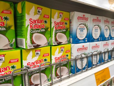 MELAKA, MALAYSIA -NOVEMBER 12, 2022: Ticari paketleme ve süpermarketlerde sergilenen işlenmiş hindistan cevizi sütü üzerine odaklanıldı. Markaya göre sıralanmış ve fiyat etiketi var..