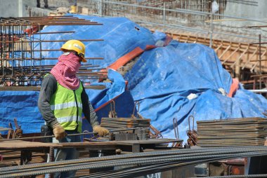 SELANGOR, MALAYSIA 15 Mart 2015: İnşaat alanındaki bar bükme alanında çalışan inşaat işçileri. 