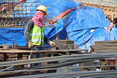 SELANGOR, MALAYSIA 15 Mart 2015: İnşaat alanındaki bar bükme alanında çalışan inşaat işçileri. 