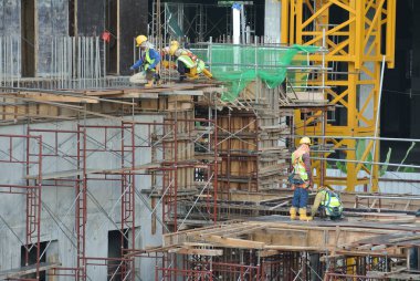 JOHOR, MALAYSIA -15 Mayıs 2016: Gündüz vakti Malezya 'nın Johor şehrinde inşaat çalışmaları sürüyor. İşçiler resmi işler ve takviye çubukları kurmakla meşguller.   