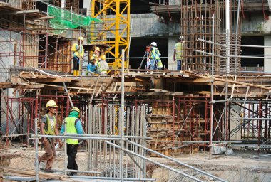 JOHOR, MALAYSIA -15 Mayıs 2016: Gündüz vakti Malezya 'nın Johor şehrinde inşaat çalışmaları sürüyor. İşçiler resmi işler ve takviye çubukları kurmakla meşguller.   