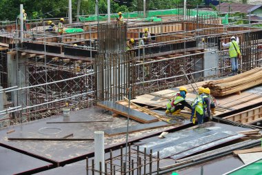 JOHOR, MALAYSIA -15 Mayıs 2016: Gündüz vakti Malezya 'nın Johor şehrinde inşaat çalışmaları sürüyor. İşçiler resmi işler ve takviye çubukları kurmakla meşguller.   