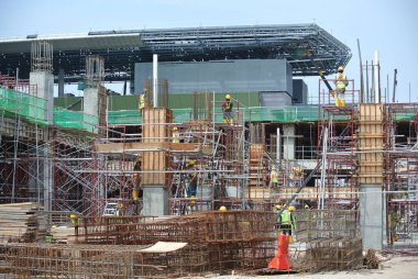 JOHOR, MALAYSIA -15 Mayıs 2016: Gündüz vakti Malezya 'nın Johor şehrinde inşaat çalışmaları sürüyor. İşçiler resmi işler ve takviye çubukları kurmakla meşguller.   