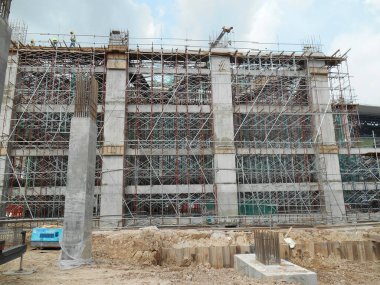 JOHOR, MALAYSIA -15 Mayıs 2016: Gündüz vakti Malezya 'nın Johor şehrinde inşaat çalışmaları sürüyor. İşçiler resmi işler ve takviye çubukları kurmakla meşguller.   