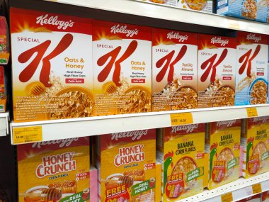 MELAKA, MALAYSIA -EKİM 1, 2022: Kahvaltı olarak çeşitli markalardan gelen çeşitli aromalı mısır gevrekleri. Ticari bir karton kutuya konmuş ve müşteriler için sergileniyor. Her ögenin bir fiyat etiketi var.