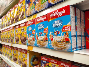 MELAKA, MALAYSIA -EKİM 1, 2022: Kahvaltı olarak çeşitli markalardan gelen çeşitli aromalı mısır gevrekleri. Ticari bir karton kutuya konmuş ve müşteriler için sergileniyor. Her ögenin bir fiyat etiketi var.