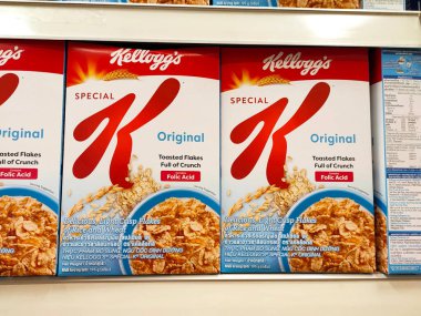 MELAKA, MALAYSIA -EKİM 1, 2022: Kahvaltı olarak çeşitli markalardan gelen çeşitli aromalı mısır gevrekleri. Ticari bir karton kutuya konmuş ve müşteriler için sergileniyor. Her ögenin bir fiyat etiketi var.