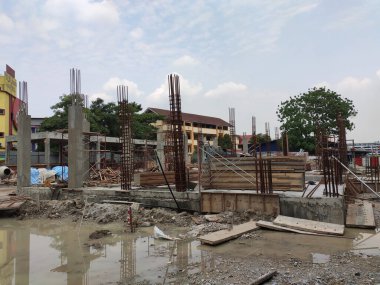 MELAKA, MALAYSIA - 19 HAZİRAN 2022: Tam gaz ilerleyen bir inşaat alanının manzarası. Makineler ve işçiler iş yapmakla meşguller. Güvenlik seviyesi gerekli standartlara ulaşacak şekilde sağlanmıştır..