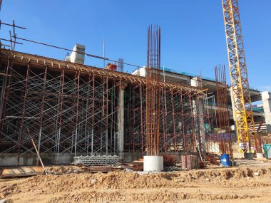 MELAKA, MALAYSIA - 19 HAZİRAN 2022: Tam gaz ilerleyen bir inşaat alanının manzarası. Makineler ve işçiler iş yapmakla meşguller. Güvenlik seviyesi gerekli standartlara ulaşacak şekilde sağlanmıştır..