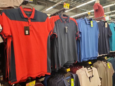 KUALA LUMPUR, MALAYSIA -JULY 8, 2022: Various types of adult men's clothes are hung and displayed for sale. Separated by type and fashion. Have a price tag for customer reference.