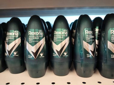 MELAKA, MALAYSIA - JULY 5, 2022: Selected focused on male and female deodorants in various brands and fragrances. Displayed on a shelf for sale in a store. Each item is provided with a price tag.