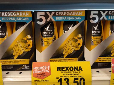 MELAKA, MALAYSIA - JULY 5, 2022: Selected focused on male and female deodorants in various brands and fragrances. Displayed on a shelf for sale in a store. Each item is provided with a price tag.