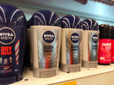 MELAKA, MALAYSIA - JULY 5, 2022: Selected focused on male and female deodorants in various brands and fragrances. Displayed on a shelf for sale in a store. Each item is provided with a price tag.