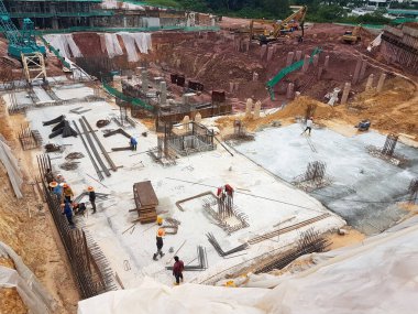 KUALA LUMPUR, MALAYSIA - OCTOBER 5, 2022: Building foundation construction work is being carried out briskly at the construction site. Heavy machinery and construction workers are busy doing work.