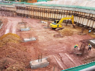 KUALA LUMPUR, MALAYSIA - OCTOBER 5, 2022: Building foundation construction work is being carried out briskly at the construction site. Heavy machinery and construction workers are busy doing work.