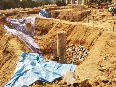 KUALA LUMPUR, MALAYSIA - OCTOBER 5, 2022: Building foundation construction work is being carried out briskly at the construction site. Heavy machinery and construction workers are busy doing work.