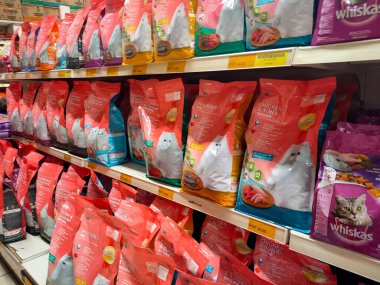 MELAKA, MALAYSIA -JANUARY 9, 2022: Cat food in commercial packs displayed for sale in a supermarket. Placed on the sales rack, and separated by brand and flavor. Has a price tag.