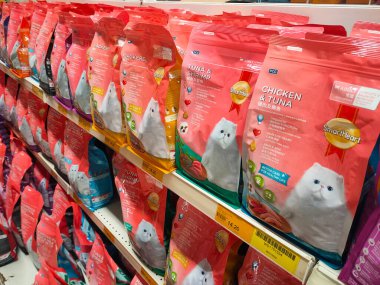 MELAKA, MALAYSIA -JANUARY 9, 2022: Cat food in commercial packs displayed for sale in a supermarket. Placed on the sales rack, and separated by brand and flavor. Has a price tag.