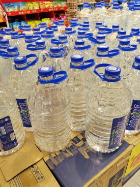 KUALA LUMPUR, MALAYSIA -MAY 1, 2022: Mineral water is packaged in plastic bottles and labeled with various brands. Displayed on a shelf inside a supermarket. Placed with a price tag
