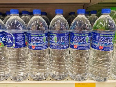 KUALA LUMPUR, MALAYSIA -MAY 1, 2022: Mineral water is packaged in plastic bottles and labeled with various brands. Displayed on a shelf inside a supermarket. Placed with a price tag