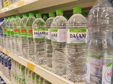 KUALA LUMPUR, MALAYSIA -MAY 1, 2022: Mineral water is packaged in plastic bottles and labeled with various brands. Displayed on a shelf inside a supermarket. Placed with a price tag