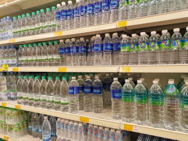 KUALA LUMPUR, MALAYSIA -MAY 1, 2022: Mineral water is packaged in plastic bottles and labeled with various brands. Displayed on a shelf inside a supermarket. Placed with a price tag
