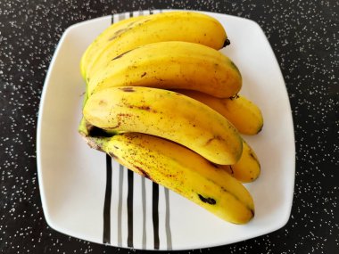 MELAKA, MALAYSIA -MARCH 6, 2022: Ripe bananas on a plate on the table. Served to eat. This banana is ripe enough and yellow in color, suitable for eating just like that.