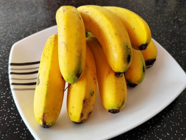 MELAKA, MALAYSIA -MARCH 6, 2022: Ripe bananas on a plate on the table. Served to eat. This banana is ripe enough and yellow in color, suitable for eating just like that.