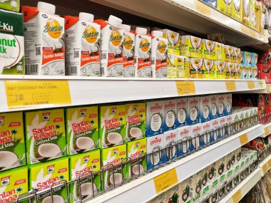 JOHOR, MALAYSIA -NOVEMBER 12, 2022: Ticari paketleme ve süpermarketlerde sergilenen işlenmiş hindistan cevizi sütü üzerine odaklanmış. Markaya göre sıralanmış ve fiyat etiketi var..