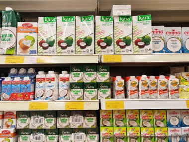 JOHOR, MALAYSIA -NOVEMBER 12, 2022: Ticari paketleme ve süpermarketlerde sergilenen işlenmiş hindistan cevizi sütü üzerine odaklanmış. Markaya göre sıralanmış ve fiyat etiketi var..