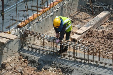 MALACCA, MALAYSIA -MARCH 29, 2016: Construction workers fabricating steel reinforcement bar at the construction site in Malacca, Malaysia. The reinforcement bar was ties together using tiny wire.  