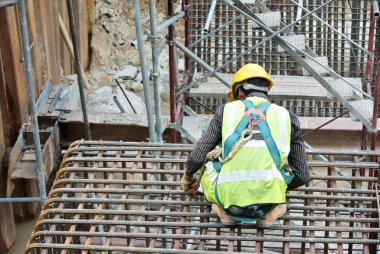 JOHOR, MALAYSIA - MARCH 03, 2015: Construction workers fabricating pile cap steel reinforcement bar at the construction site.  