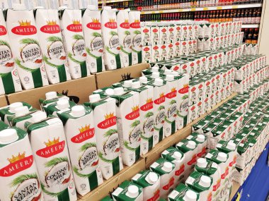 JOHOR, MALAYSIA -NOVEMBER 12, 2022: Ticari paketleme ve süpermarketlerde sergilenen işlenmiş hindistan cevizi sütü üzerine odaklanmış. Markaya göre sıralanmış ve fiyat etiketi var..