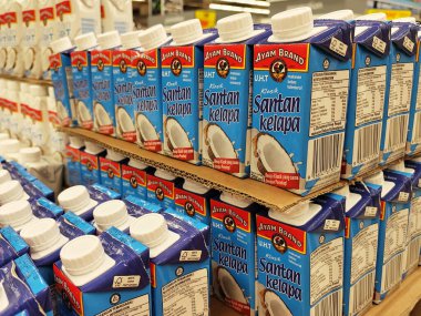 JOHOR, MALAYSIA -NOVEMBER 12, 2022: Ticari paketleme ve süpermarketlerde sergilenen işlenmiş hindistan cevizi sütü üzerine odaklanmış. Markaya göre sıralanmış ve fiyat etiketi var..