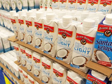 JOHOR, MALAYSIA -NOVEMBER 12, 2022: Ticari paketleme ve süpermarketlerde sergilenen işlenmiş hindistan cevizi sütü üzerine odaklanmış. Markaya göre sıralanmış ve fiyat etiketi var..