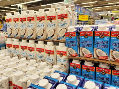 JOHOR, MALAYSIA -NOVEMBER 12, 2022: Ticari paketleme ve süpermarketlerde sergilenen işlenmiş hindistan cevizi sütü üzerine odaklanmış. Markaya göre sıralanmış ve fiyat etiketi var..