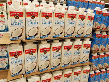 JOHOR, MALAYSIA -NOVEMBER 12, 2022: Ticari paketleme ve süpermarketlerde sergilenen işlenmiş hindistan cevizi sütü üzerine odaklanmış. Markaya göre sıralanmış ve fiyat etiketi var..