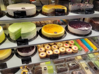 MELAKA, MALAYSIA - 4 Mart 2022: Dondurucu ekranda çeşitli aromalı çeşitli pastalar sergilenmektedir. Müşterilerin satın almasını kolaylaştırmak için fiyat etiketleri sağlanır.