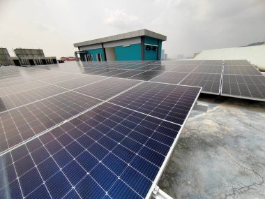 JOHOR, MALAYSIA - 23 Mart 2016: Güneş enerjisini toplamak ve elektrik enerjisine dönüştürmek için güneş çiftliğindeki güneş paneli. Uygun güneş ışığı için binanın çatısına yerleştirildi..