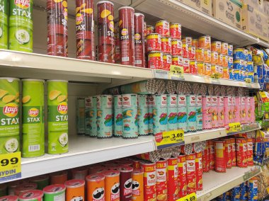 SEREMBAN, MALAYSIA - 30 Haziran 2024: Bir süpermarketteki satış raflarında silindirik paketlerde çeşitli patates cipsi markaları satılıyor.