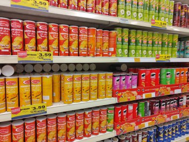 SEREMBAN, MALAYSIA - 30 Haziran 2024: Bir süpermarketteki satış raflarında silindirik paketlerde çeşitli patates cipsi markaları satılıyor.
