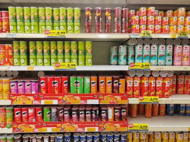 SEREMBAN, MALAYSIA - 30 Haziran 2024: Bir süpermarketteki satış raflarında silindirik paketlerde çeşitli patates cipsi markaları satılıyor.