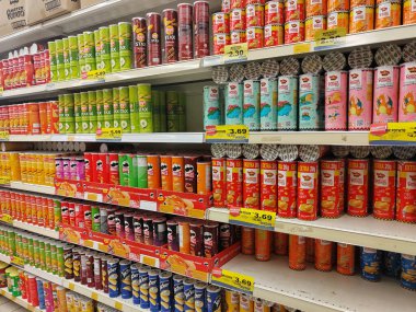 SEREMBAN, MALAYSIA - 30 Haziran 2024: Bir süpermarketteki satış raflarında silindirik paketlerde çeşitli patates cipsi markaları satılıyor.