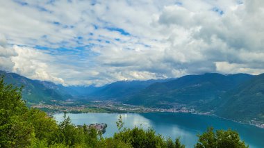 Lombardy, İtalya 'da bulutlu bir günde Iseo Gölü ve çevresindeki dağlara bakan manzaralı bir manzara..