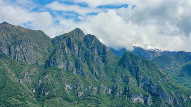 İtalya 'nın Lombardiya Gölü' nün yukarısındaki Alpler 'in engebeli, bulutlarla kaplı zirvelerine dramatik bir bakış açısı..